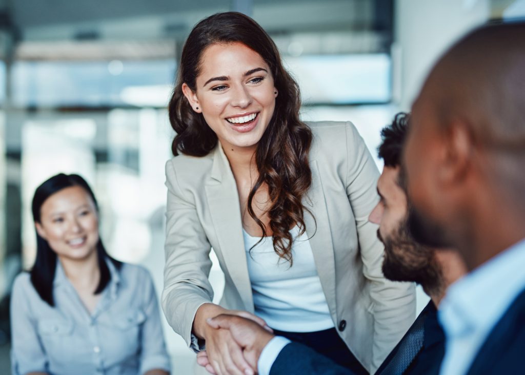 Shot of a young businesswoman shaking hands with a colleague during a meeting in a modern office