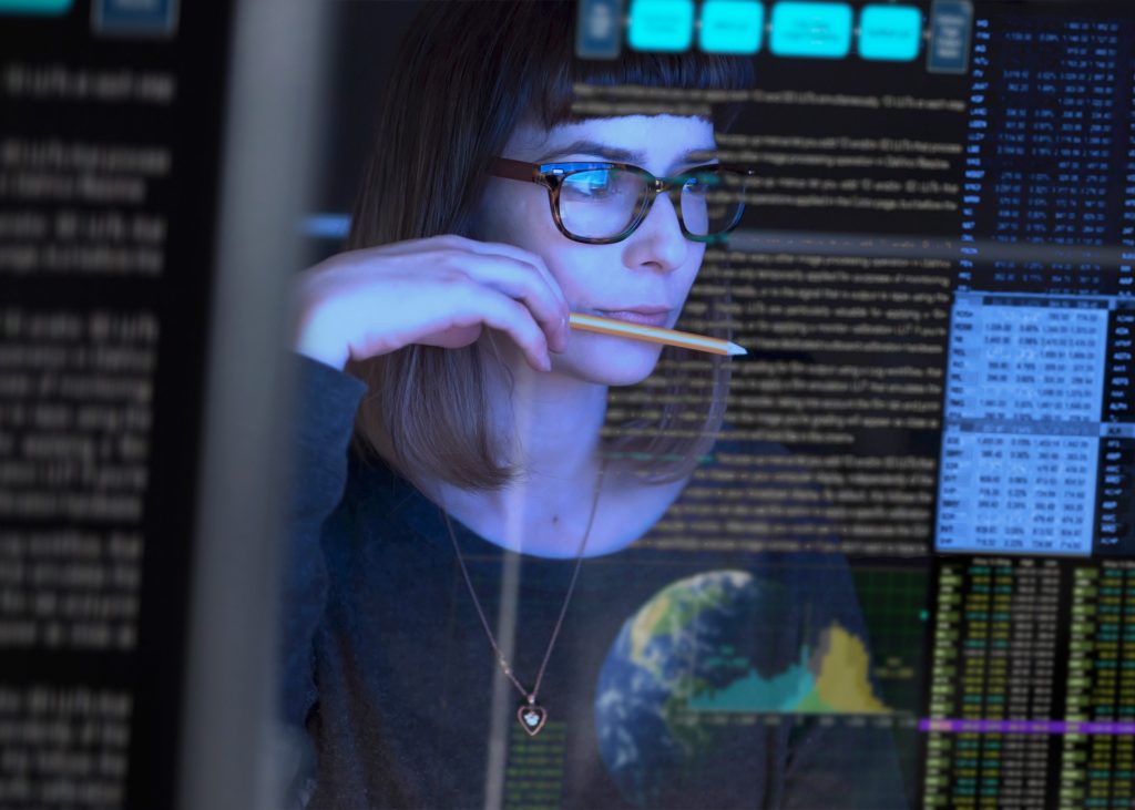 young woman studying a see through computer screen & contemplating.